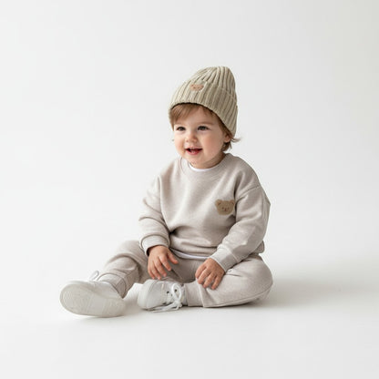 Peek Ah Boo beige fleece baby tracksuit with embroidered bear motif and matching ribbed beanie.