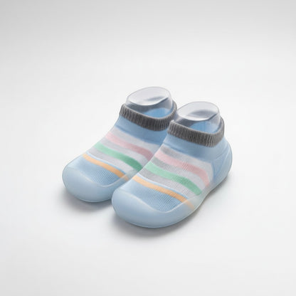 Peek Ah Boo light blue knit baby shoes with grey cuffs and pastel rainbow stripes, featuring a non-slip rubber sole.