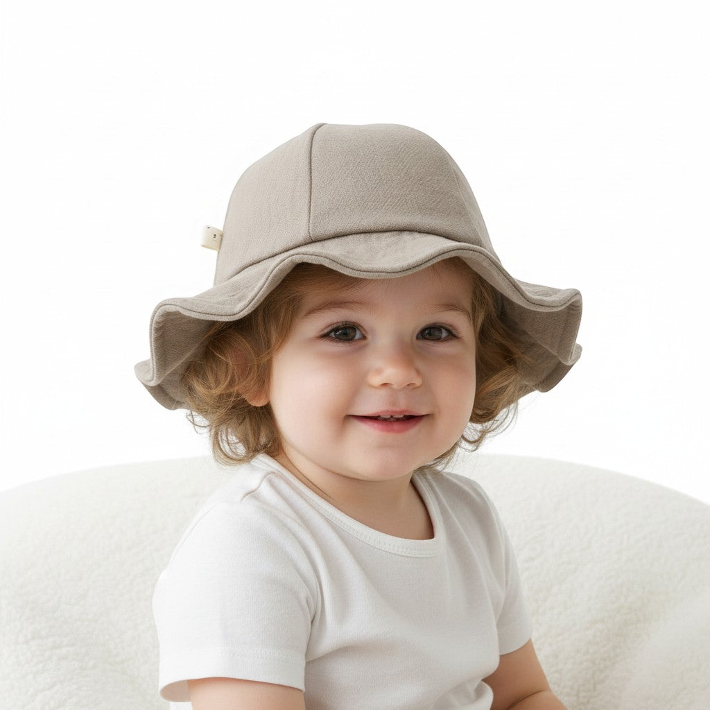 Peek Ah Boo beige linen-blend wide brim baby sun hat with a decorative bow detail and scalloped edge.